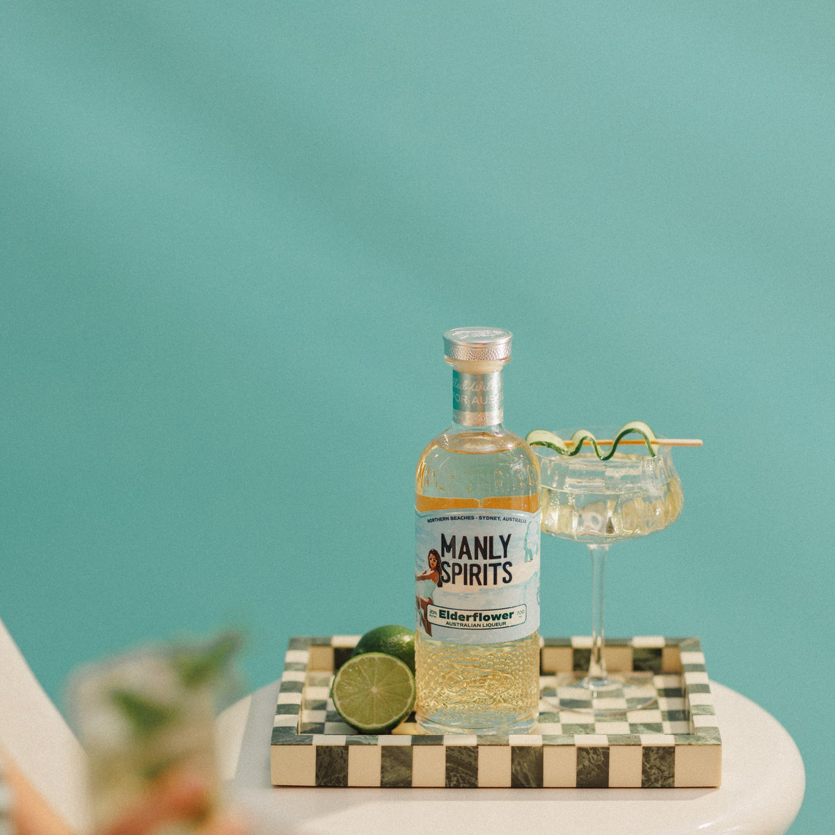 Elderflower Liqueur with limes and a spritz on a checkered tray