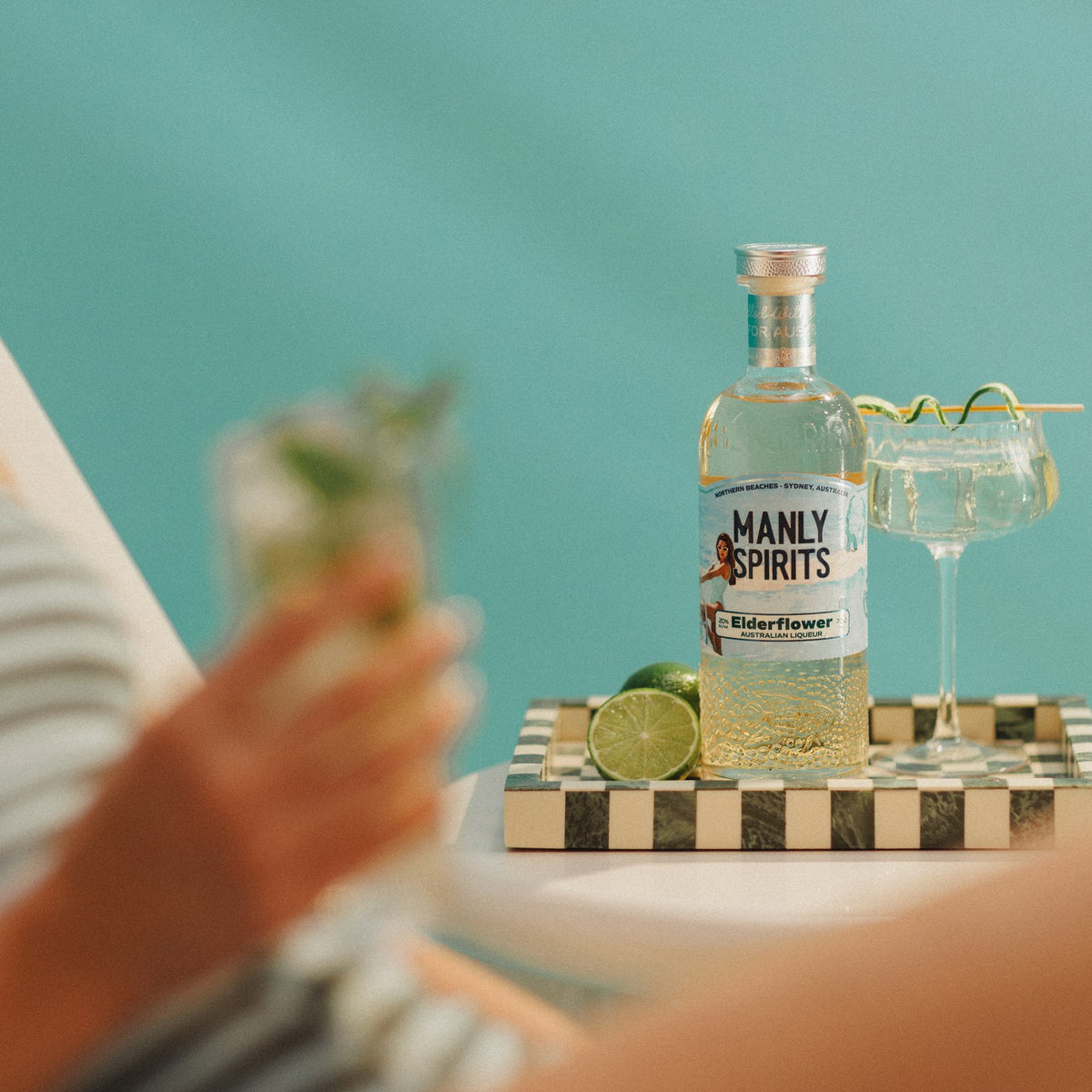 Elderflower Liqueur and a Hugo Spritz against a turquoise wall