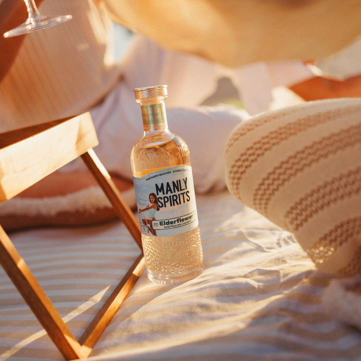 Elderflower Liqueur on a striped picnic blanket at golden hour