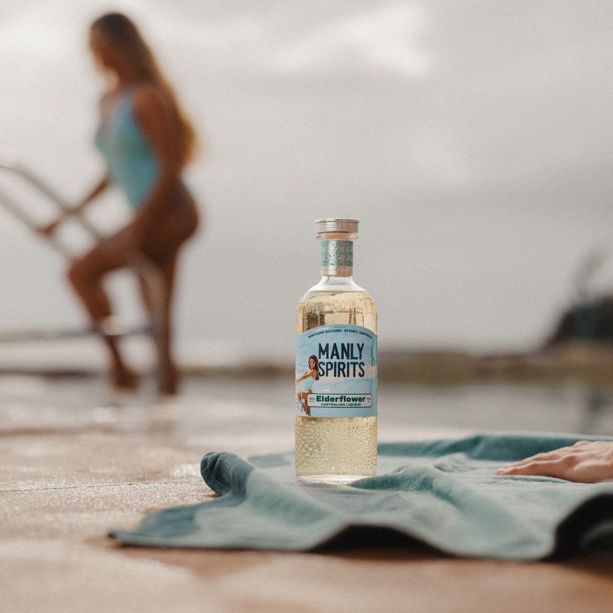 Elderflower Liqueur on a teal towel beside the pool
