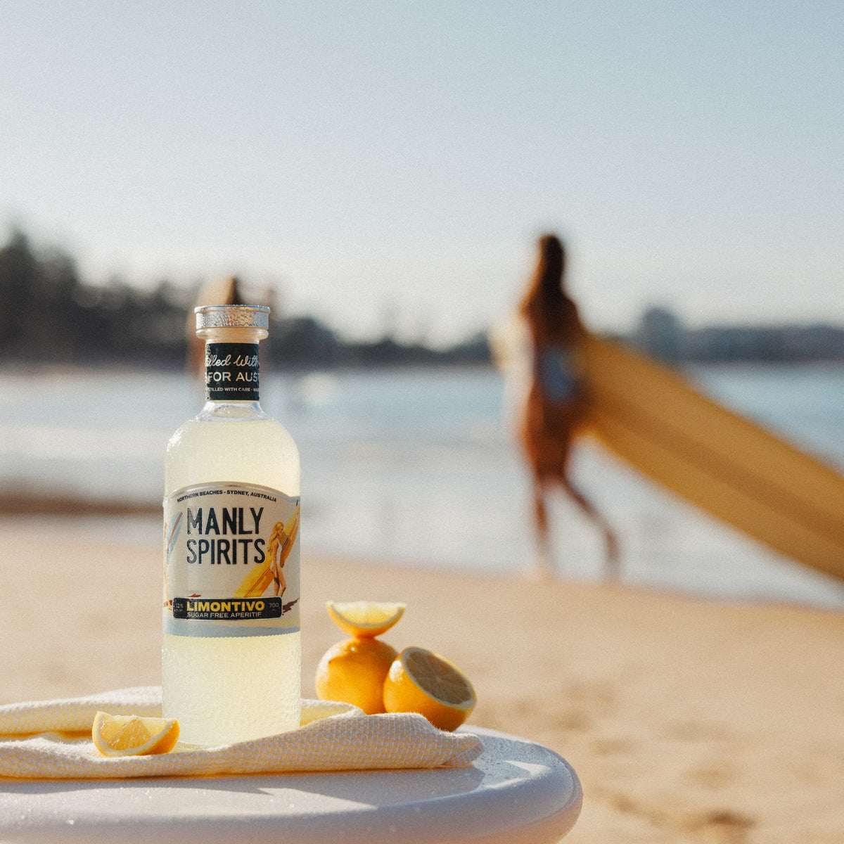 Limontivo bottle with fresh lemons on the beach