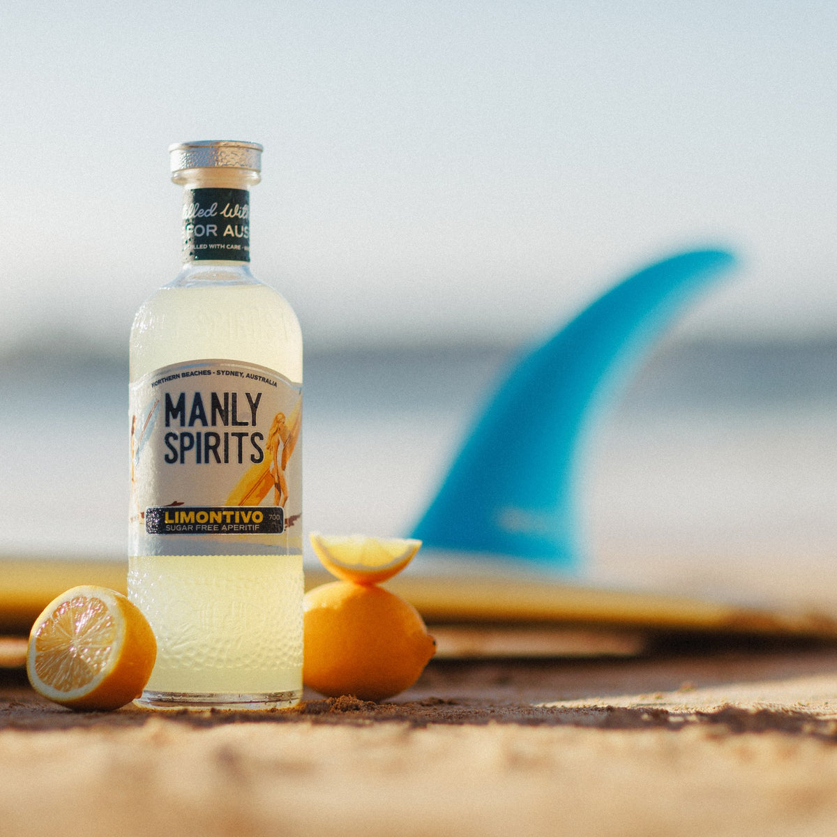 Limontivo with halved lemons on the sand beside a surfboard