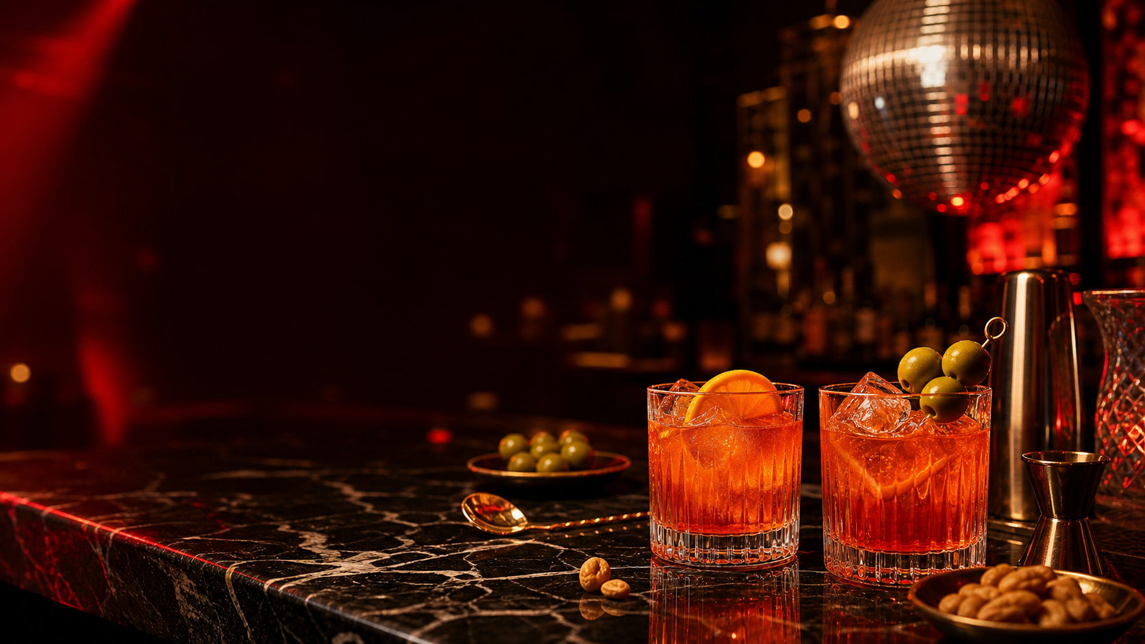 Aperitivo cocktails on a bar with warm red lighting and disco reflections
