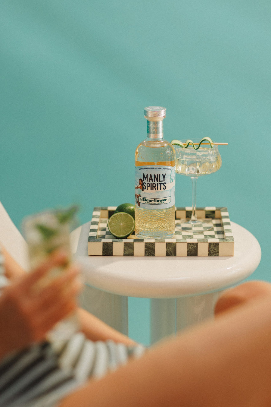 Elderflower Liqueur with limes and a spritz on a checkered tray