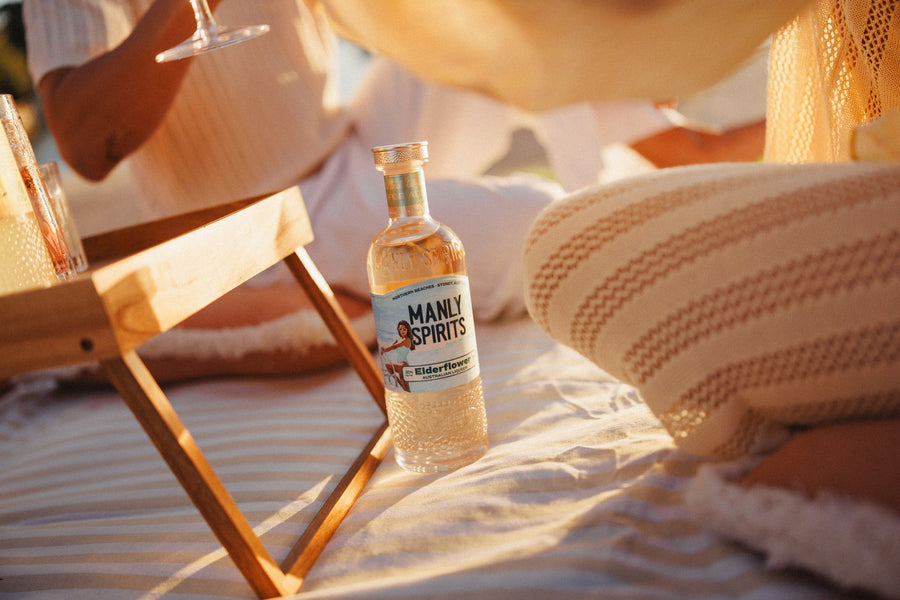 Elderflower Liqueur on a striped picnic blanket at golden hour