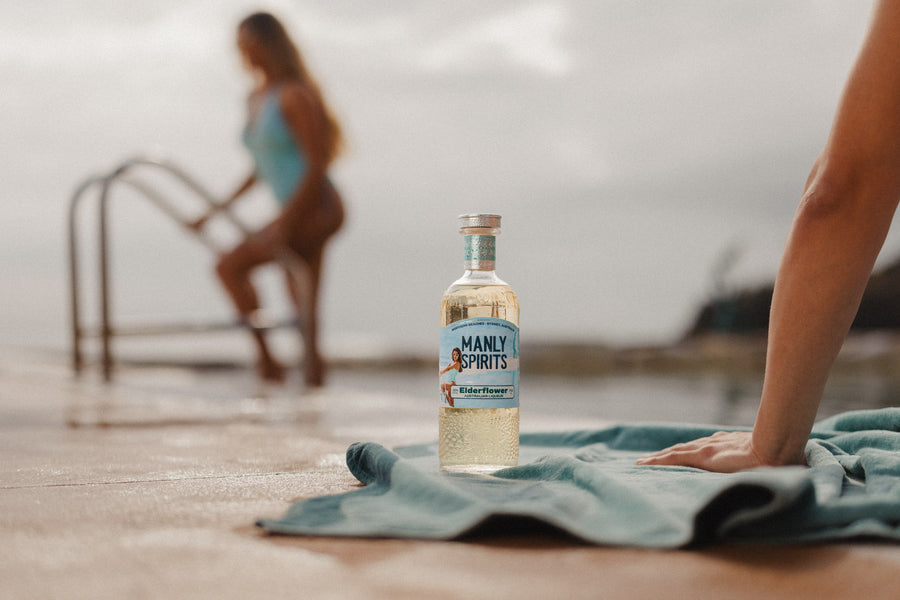 Elderflower Liqueur on a teal towel beside the pool