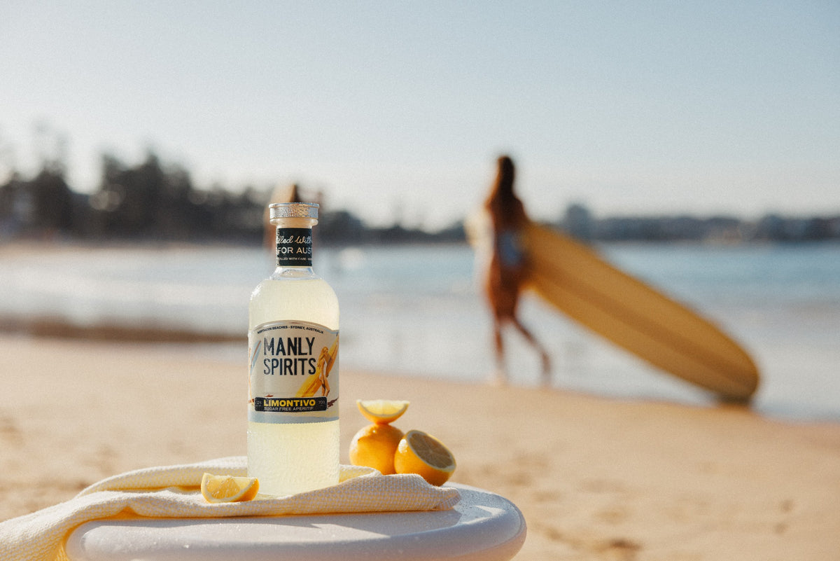 Limontivo bottle with fresh lemons on the beach