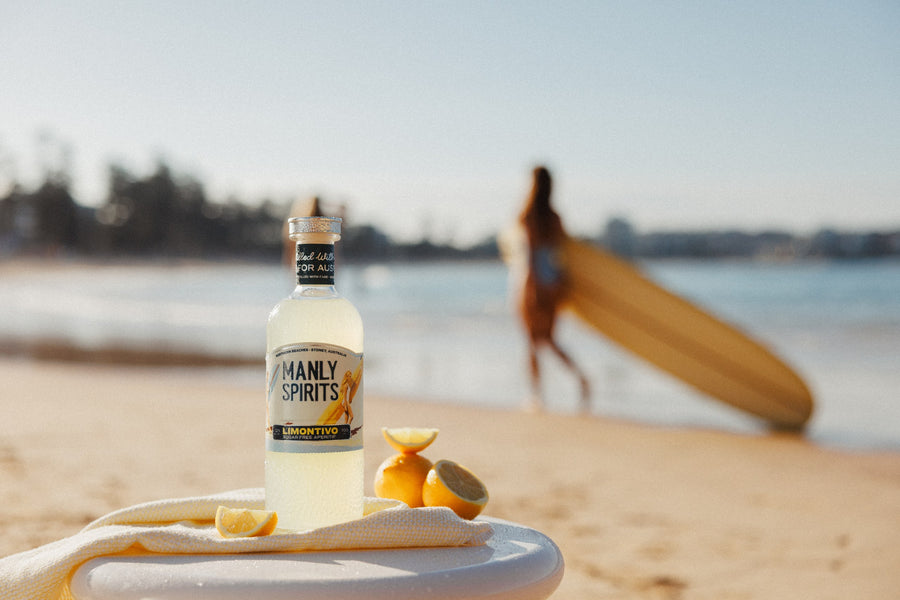 Limontivo bottle with fresh lemons on the beach