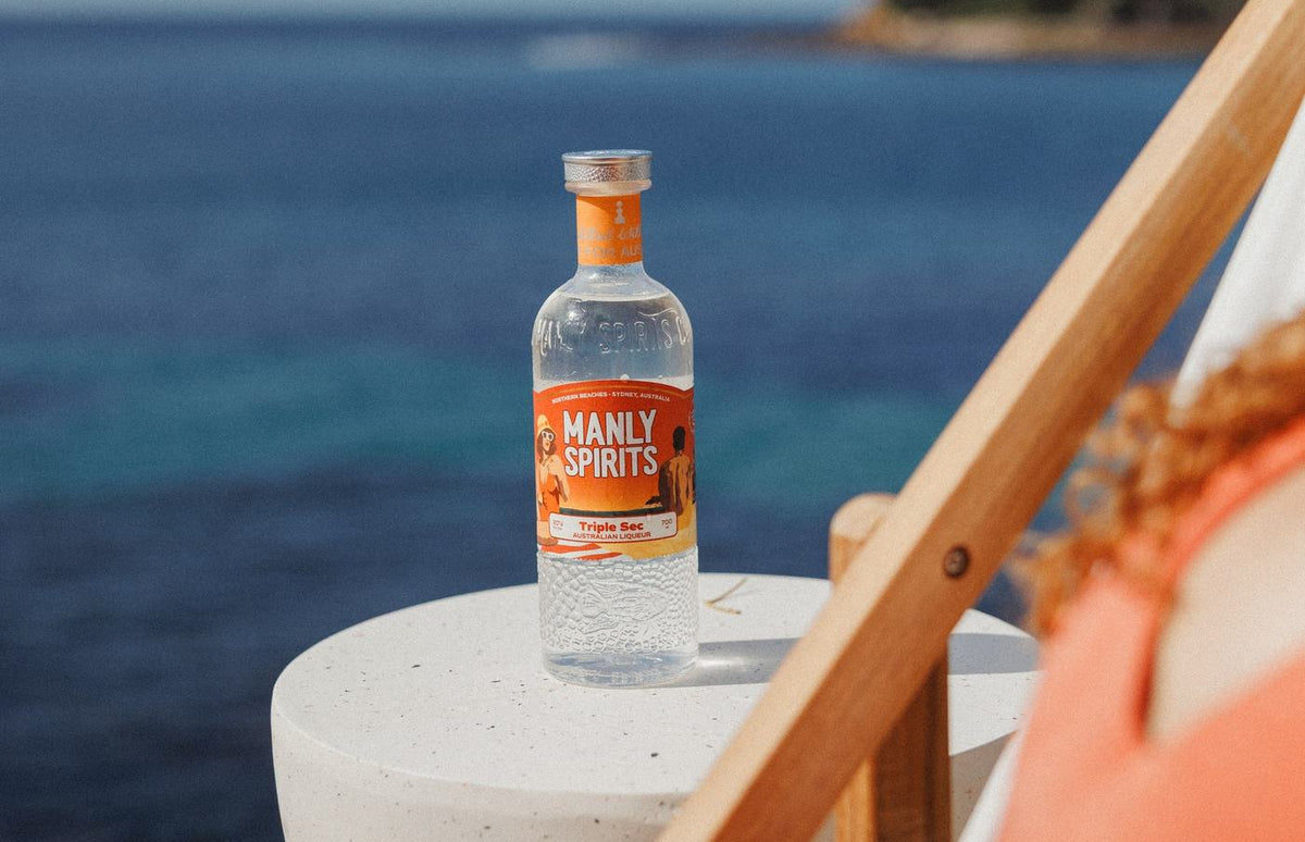 A bottle of Mandarin Triple Sec on a stone side table overlooking the sea on the Northern Beaches